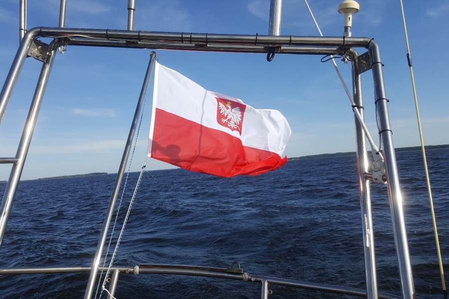 Polska Bandera powiewa na rufie jachtu s/y Dar Szczecina, w tle widać morze