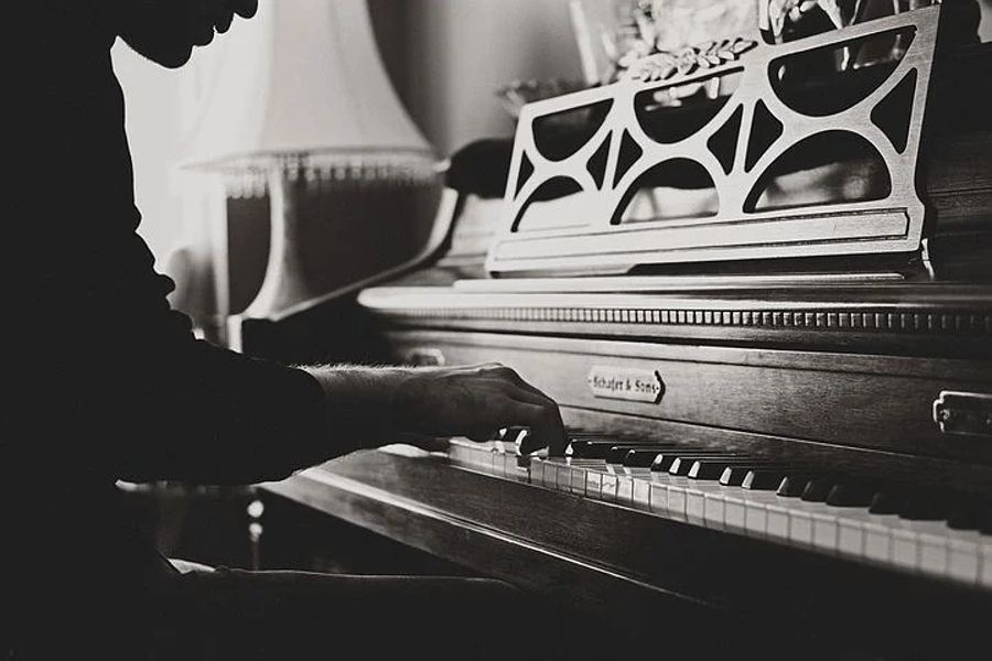 Na zdjęciu widać pianistę, grającego na zabytkowym fortepianie
