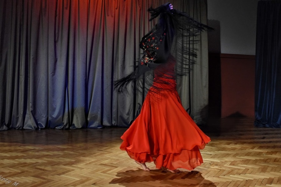 kobieta w czerwonej sukni i czarnek chuście tanczy flamenco