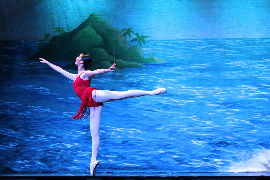 Zdjęcie przedstawia baletnicę w pozie arabesque.