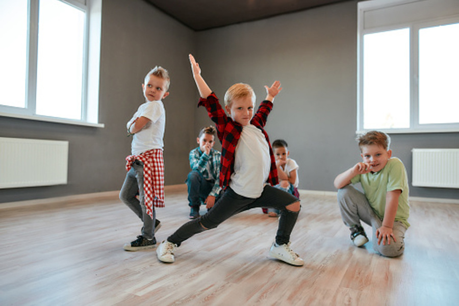 grupa dzieci stojących w pozycjach tanecznych