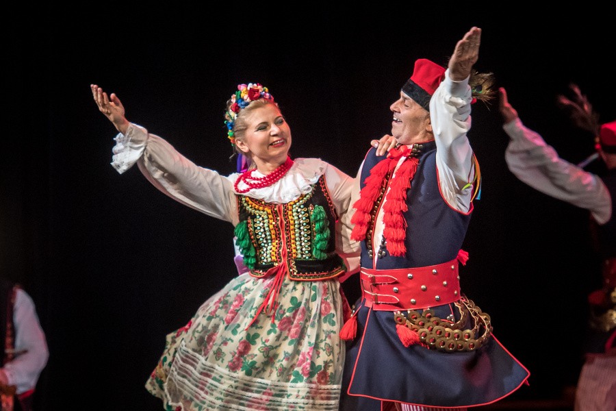 Para tańczące krakowiaka w tradycyjnych strojach krakowskich.