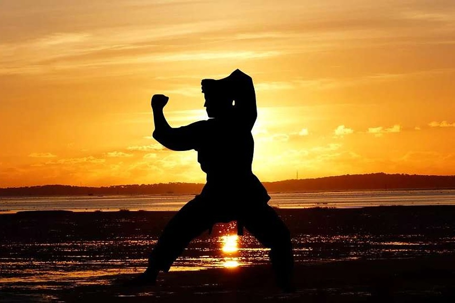 postać karateki, ćwiczącego o zachodzie słóńca