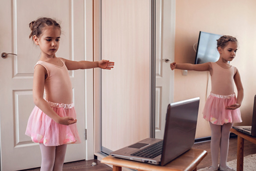 dziecko w pozycji baletowej przed komputerem