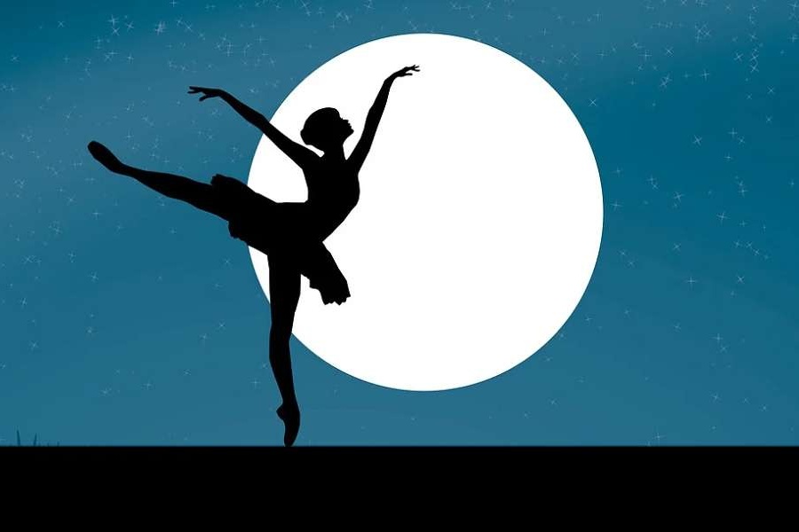 Zdjęcie przedstawia  sylwetkę tancerki  w pozie arabesque przy blasku pełni księżyca.