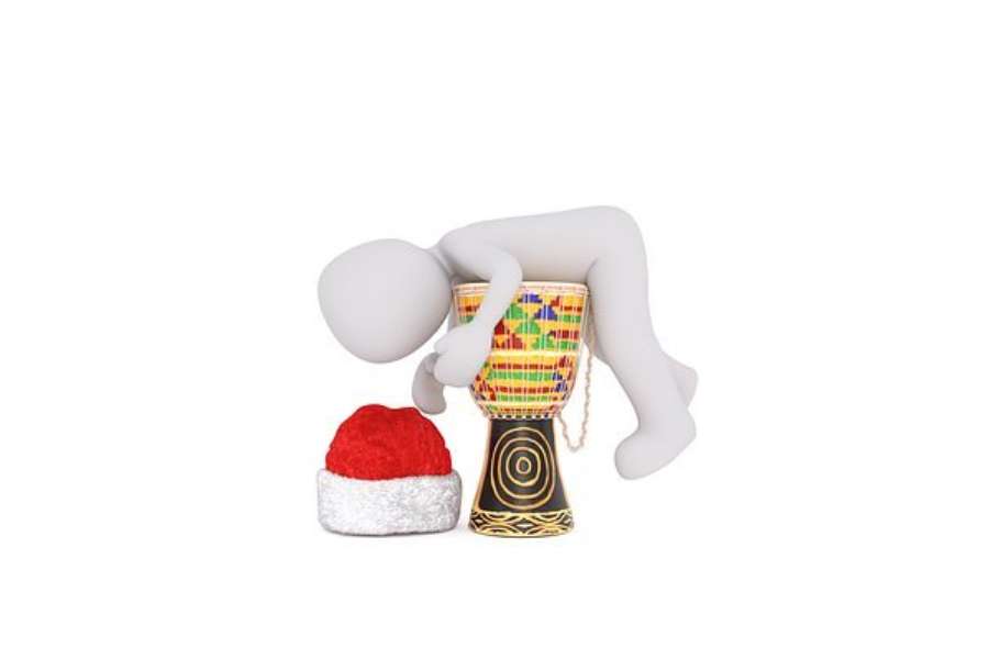 grafika przedstawia kukiełkę leżącą na djembe obok której leży czapka św. Mikołaja