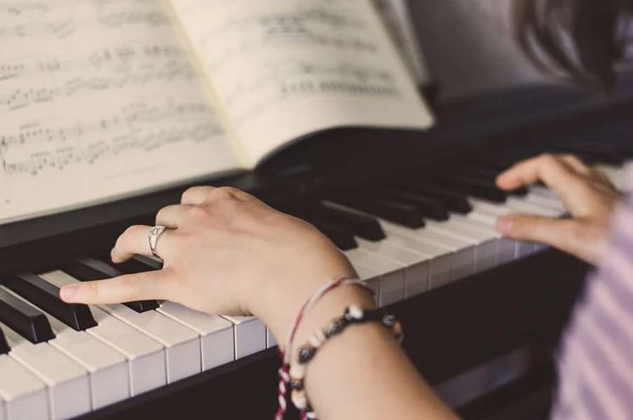 dłonie kobiety grającej na pianinie