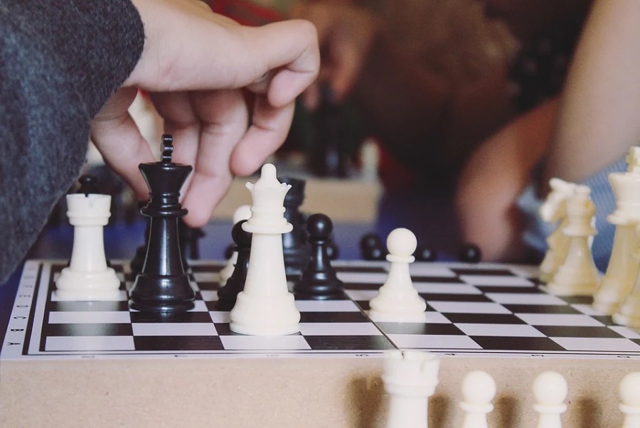 dłoń wykonująca posunięcie podczas gry w szachy