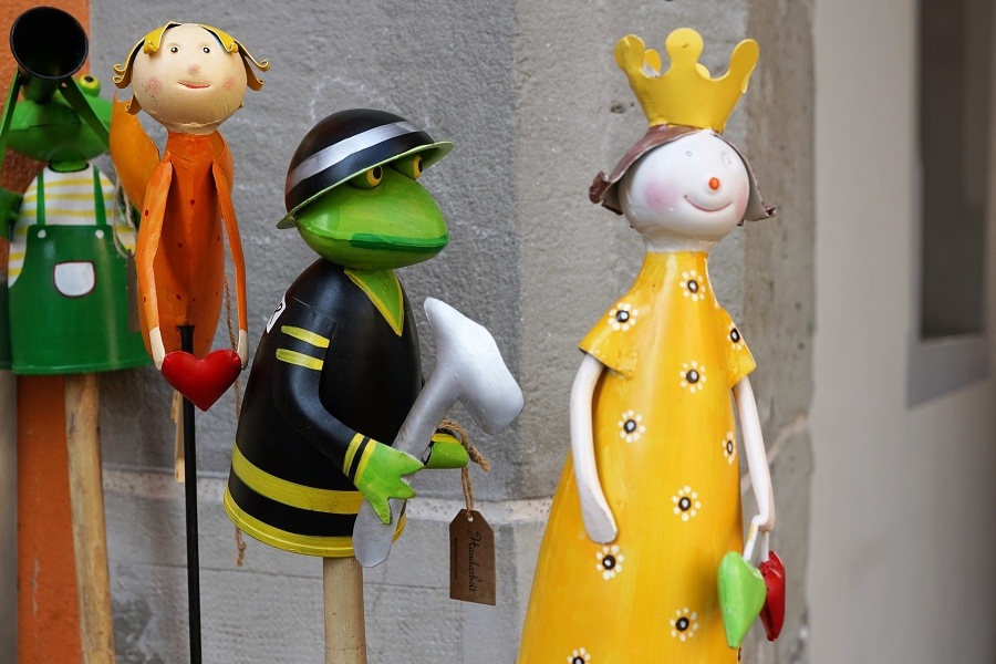 Zdjęcie przedstawia cztery teatralne lalki, na pierwszym planie żaba i królewna