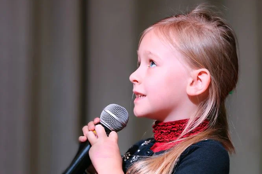 mała dziewczynka śpiewa do mikrofonu