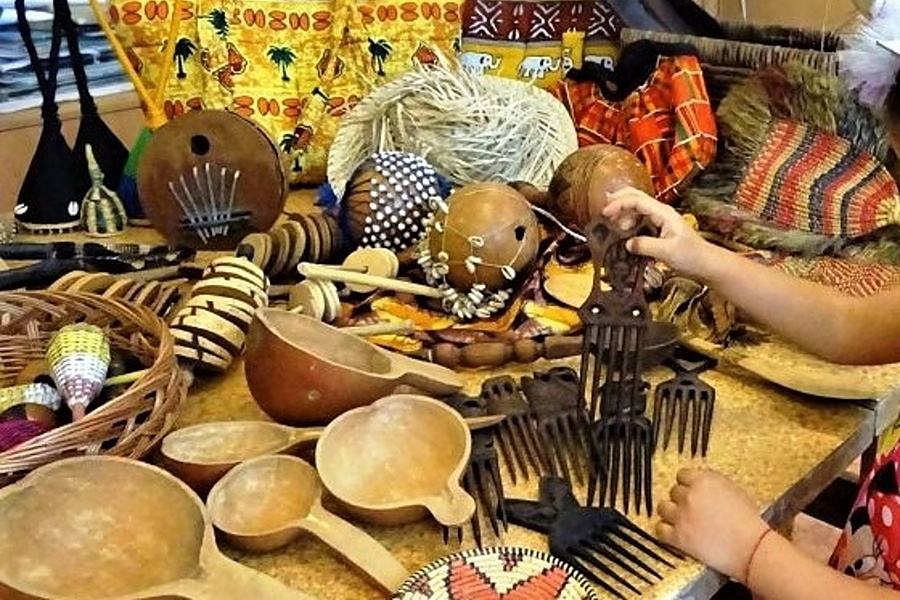 Przedmioty wykonane z naturalnych materiałów z Afryki( grzechotki, łyżki, grzebienie, torby) leżą na stole