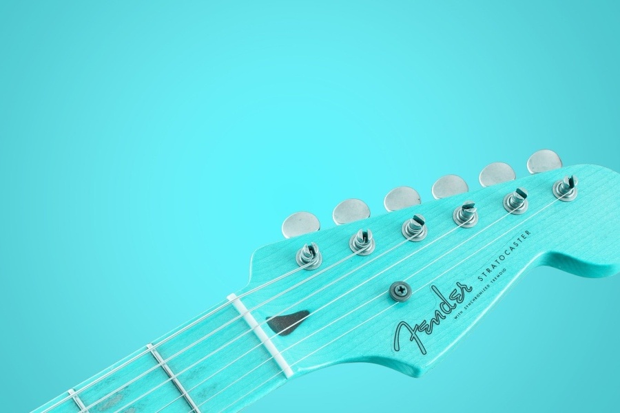 Niebieska główka gitary elektrycznej na błękitnym tle