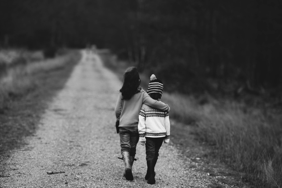 czarno-biała fotografia z dwójką dzieci idących drogą