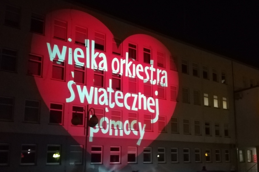 Napis "Wielka Orkiestra Świątecznej Pomocy" wyświetlony na fasadzie budynku