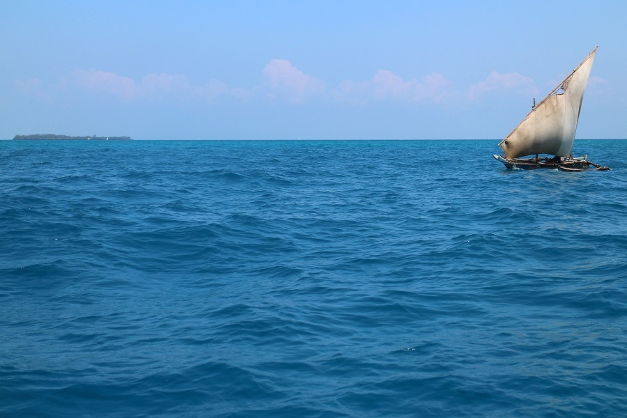 Zdjęcie przedstawia łódź z rozwiniętym żaglem na pełnym morzu