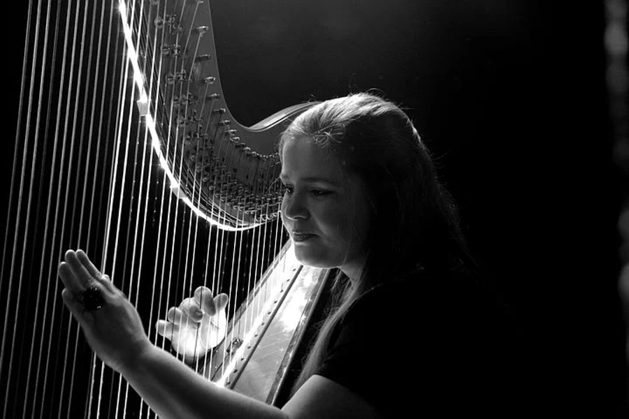 mloda kobieta grajaca na harfie