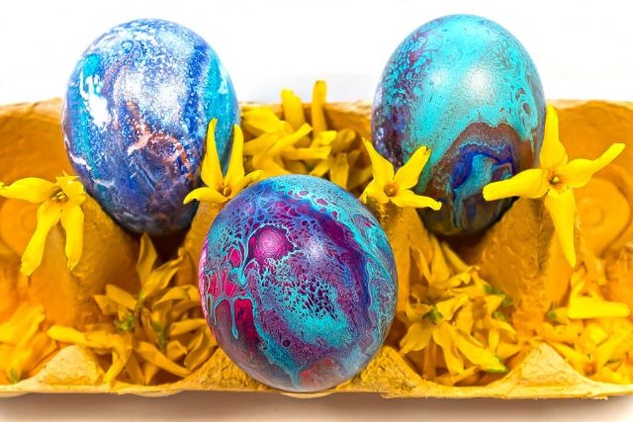 trzy jajka pomalowane w nieregularne plamy w tonacji niebieskiej