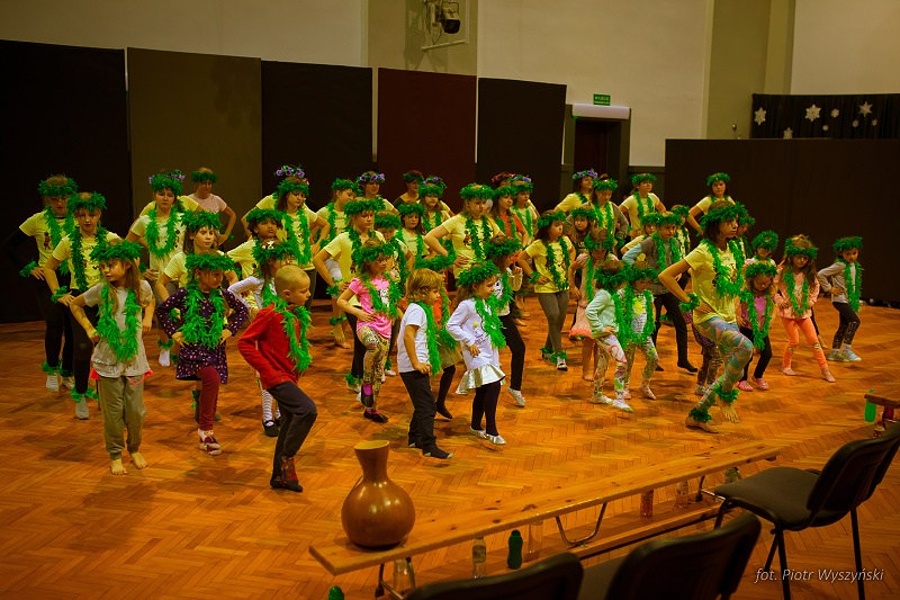 Grupa osób w różnym wieku tańcząca na scenie.